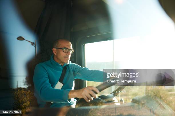 serious truck driver on his journey focused on the road - vrachtwagen stockfoto's en -beelden