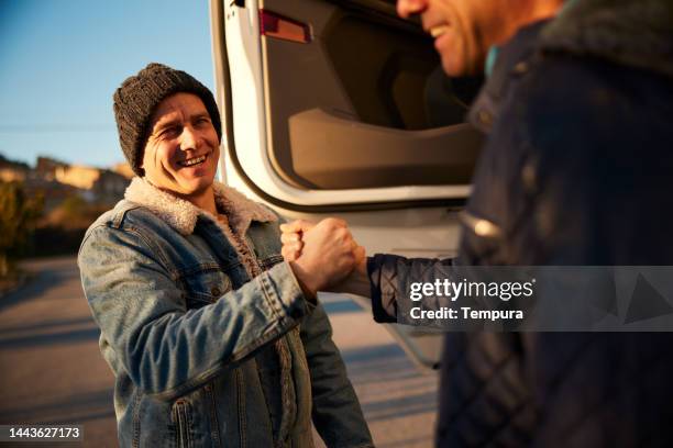 two trucker friends, happy to see each other again, shaking hands. - handshake closeup stock pictures, royalty-free photos & images