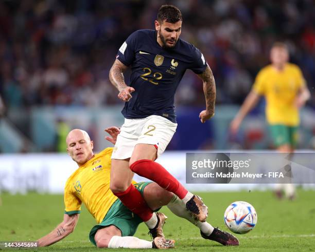 Theo Hernandez of France is tackled by Aaron Mooy of Australia during the FIFA World Cup Qatar 2022 Group D match between France and Australia at Al...