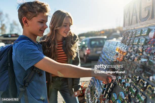 teenage kids buying souvenir magnets at street stand - souvenir magnet stock pictures, royalty-free photos & images