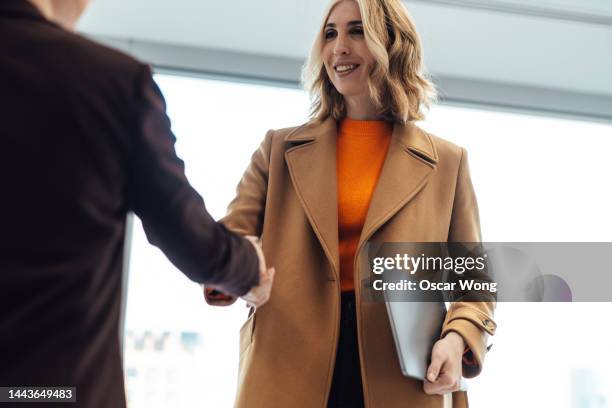 two businesswomen making business deal with handshake - career ladder stock-fotos und bilder