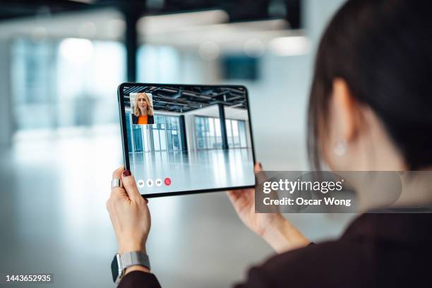 female property agent showing customer around empty office space through video call on digital tablet - virtual showing stock pictures, royalty-free photos & images