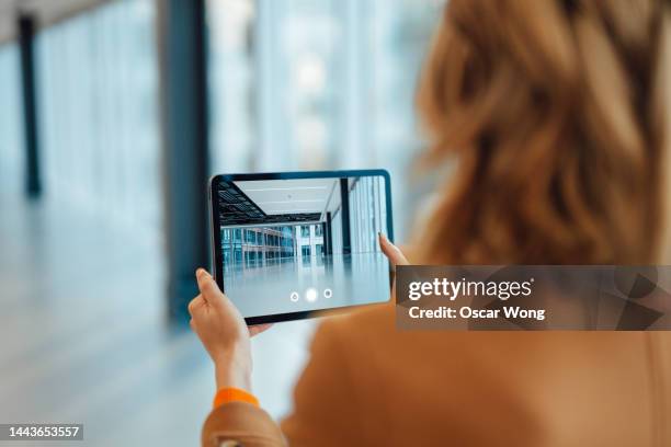 estate agent showing a new office space through an online video call - tablet screen stock-fotos und bilder