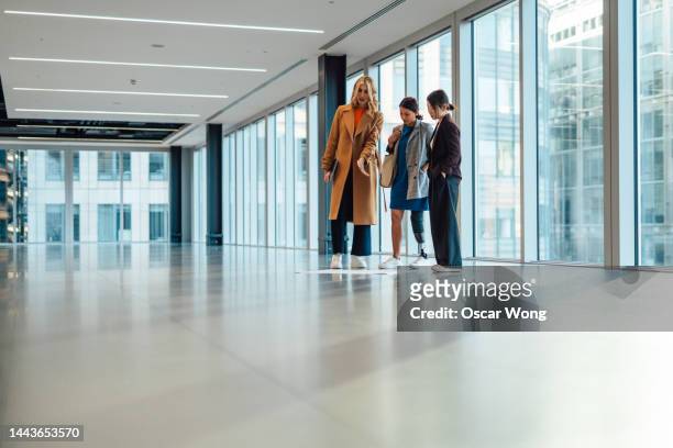 businesswoman going through interior design and plan in empty office space with colleagues, architect and interior designer - commercial real estate agent stock pictures, royalty-free photos & images