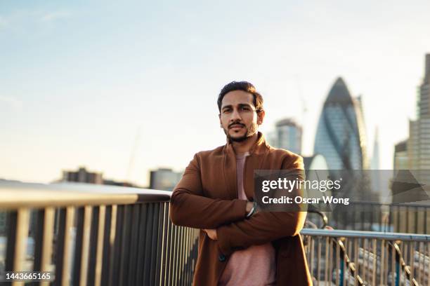 portrait of businessman on rooftop with arms crossed - arrogant man stock pictures, royalty-free photos & images