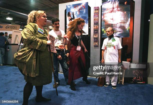 Man attached by leash to a dominatrix at the adult section of The Consumer Electronics Show on January 8, 1999 in Las Vegas, Nevada.