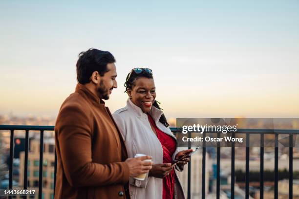 corporate  business people in discussion walking on rooftop - conversation sunset stock-fotos und bilder