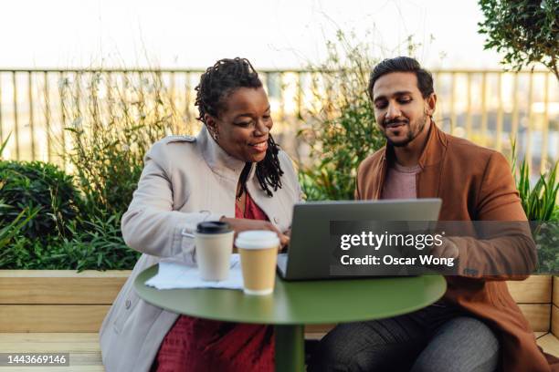 coworkers discussing project and having work meeting at rooftop garden in high-rise office building - business meeting 2 people fotografías e imágenes de stock