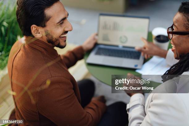 over the shoulder view of coworkers discussing project and having work meeting at rooftop garden in high-rise office building - business man sitting banking imagens e fotografias de stock