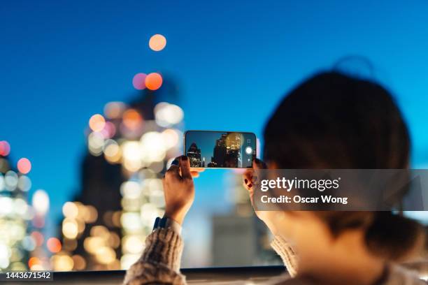 young asian female traveller enjoying holiday, exploring and strolling in downtown city street at night - edge of the city 1957 stockfoto's en -beelden