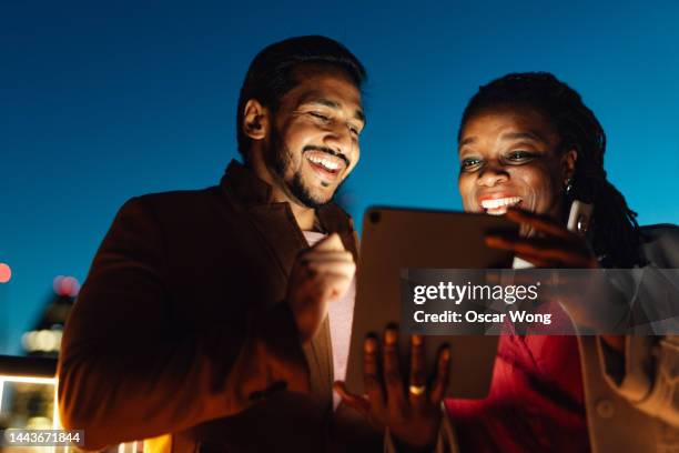 close-up shot of two adults having video call on digital tablet against urban cityscape - like a boss film fotografías e imágenes de stock