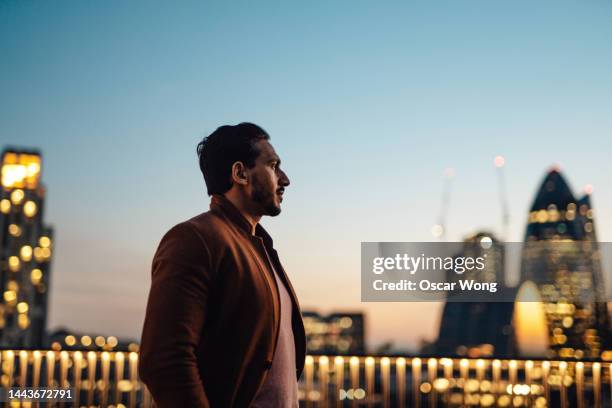 businessman looking over city at rooftop in high-rise business building - self doubt ストックフォトと画像