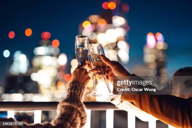 close up of business colleagues toasting with champagne in rooftop and having friday night drinks - cocktail party fotografías e imágenes de stock