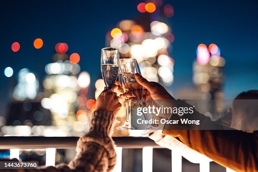 Close up of business colleagues toasting with champagne in rooftop and having Friday night drinks Close up of business colleagues toasting with champagne in rooftop and having Friday night drinks