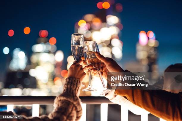 close up of business colleagues toasting with champagne in rooftop and having friday night drinks - rooftop at night bildbanksfoton och bilder