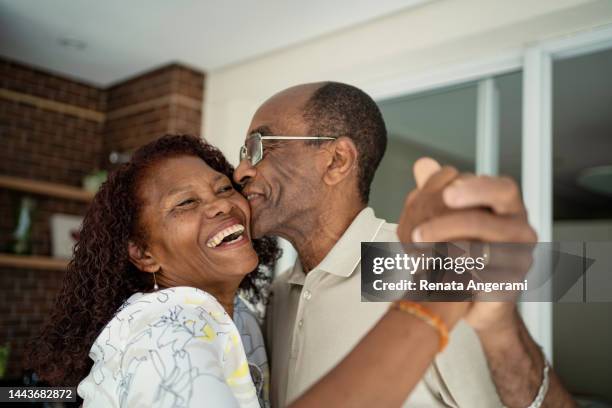 african american senior couple dancing on the balcony - love celebration stockfoto's en -beelden