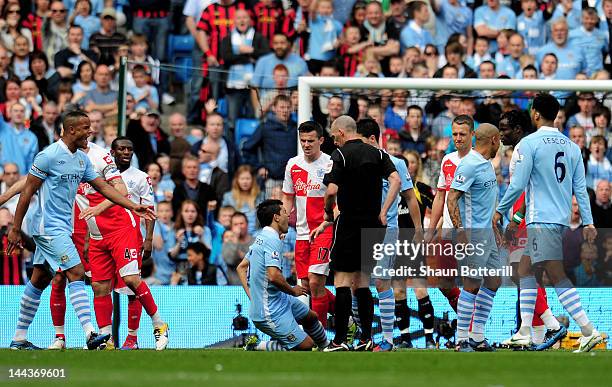 Joey Barton of QPR clashes with Sergio Aguero of Manchester City after being shown the red card by Referee Mike Dean during the Barclays Premier...