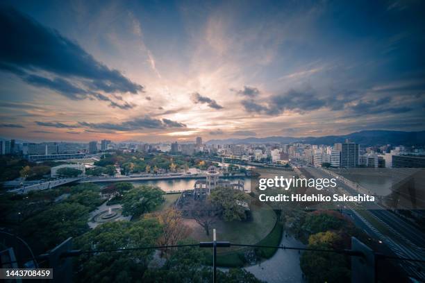 sunset over hiroshima atomic bomb dome and peace memorial park - hiroshima fotografías e imágenes de stock