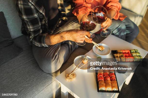 couple enjoying assorted sushi home delivery. - romantiek stockfoto's en -beelden