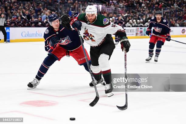 Andrew Peeke of the Columbus Blue Jackets and Zack Kassian of the Arizona Coyotes compete for the puck during a game at Nationwide Arena on October...