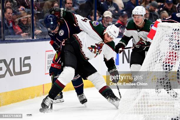 Jake Bean of the Columbus Blue Jackets and Zack Kassian of the Arizona Coyotes compete for the puck during a game at Nationwide Arena on October 25,...