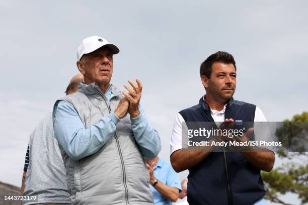 Retired mens basketball coach Roy Williams and head coach of mens golf of the University of North Carolina Andrew DiBitetto applaud a putt on the...