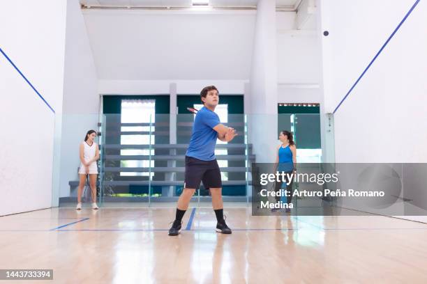 squash team bouncing balls to the wall, front view - racketball stock pictures, royalty-free photos & images