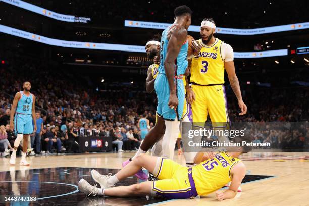 Patrick Beverley of the Los Angeles Lakers pushes Deandre Ayton of the Phoenix Suns to the ground while standing alongside Anthony Davis and Austin...