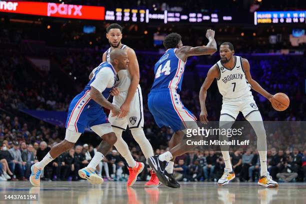 Kevin Durant of the Brooklyn Nets dribbles the ball against Paul Reed of the Philadelphia 76ers as Ben Simmons of the Brooklyn Nets sets a screen on...