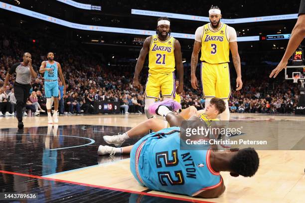 Patrick Beverley of the Los Angeles Lakers reacts after pushing Deandre Ayton of the Phoenix Suns to the ground, alongside Anthony Davis and Austin...