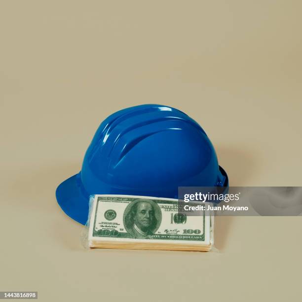 hard hat and dollar banknotes - bribing stock pictures, royalty-free photos & images