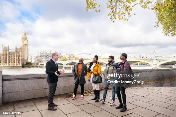 feriengruppe hört reiseführer, south bank london - big ben black and white stock-fotos und bilder