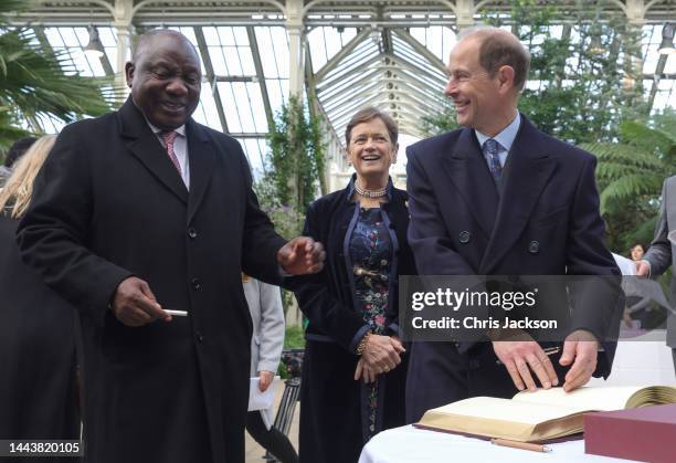 President of South Africa Cyril Ramaphosa and Prince Edward, Earl of Wessex share a joke as they sign the Visitors Book during a visit to the Royal...