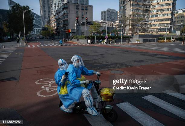 Epidemic control workers who perform nucleic acid tests wear protective clothing to protect against the spread of COVID-19 as they ride shared...