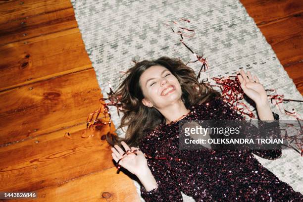 happy young woman in glittering cocktail  dress on carpet floor, flash light, user generated content - confetti floor stockfoto's en -beelden