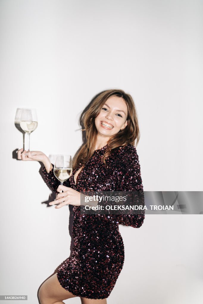 Portrait with young woman with two glasses of Champagne (flash light)