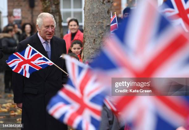 King Charles III meets pupils waving Union Jack flags from the new City junior school, based within the grounds, during a visit to The Honourable...