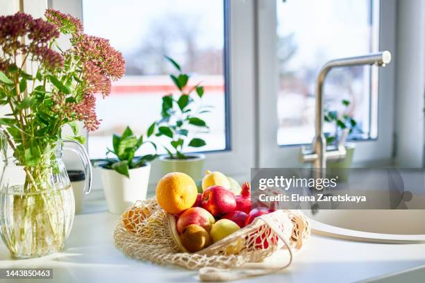 fruits in canvas bag on kitchen counter in home - bolsa reutilizable fotografías e imágenes de stock