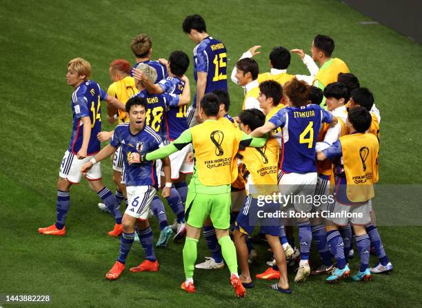 Ritsu Doan of Japan celebrates with teammates after scoring their team's first goal during the FIFA World Cup Qatar 2022 Group E match between...