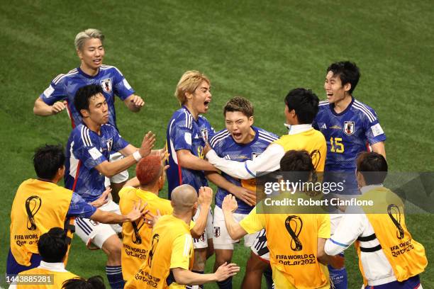 Ritsu Doan of Japan celebrates with teammates after scoring their team's first goal during the FIFA World Cup Qatar 2022 Group E match between...