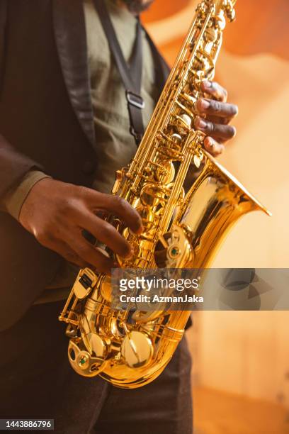 gold saxophone being played by a black male musician - saxophone 個照片及圖片檔