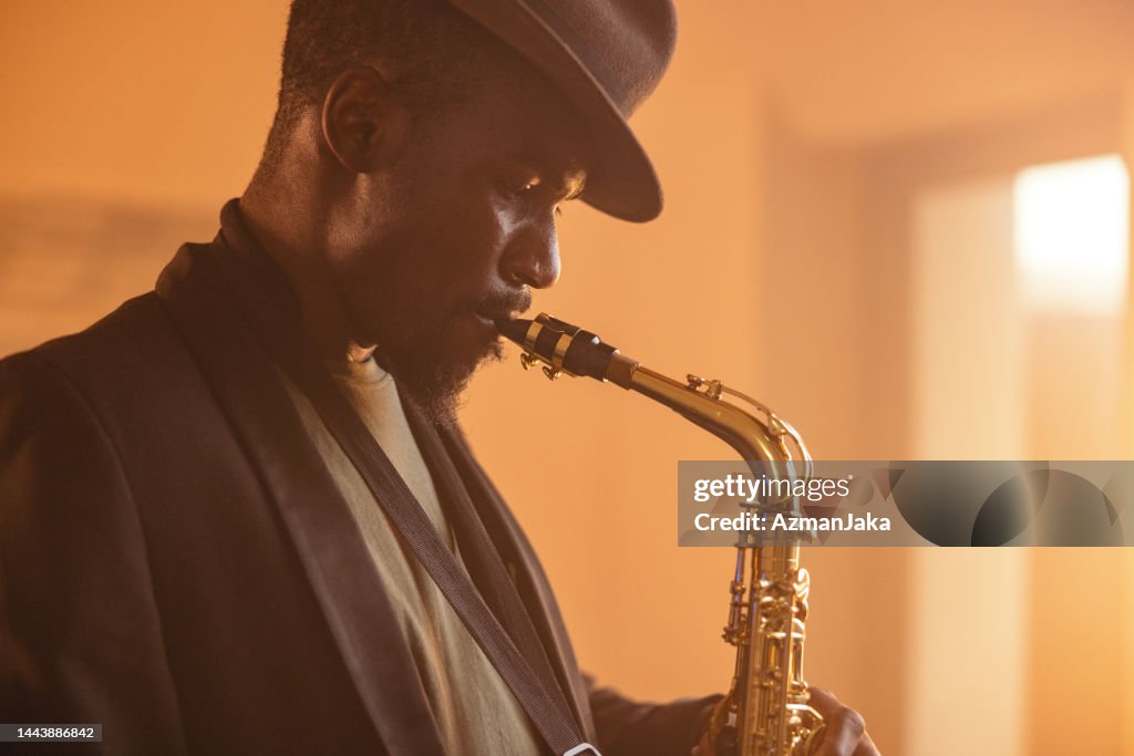 Profile of A Black Male Jazz Musician Playing A Saxophone In A Recording Studio