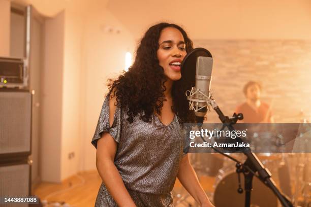 young adult black female band lead singer singing in a recording studio - lead singer stock pictures, royalty-free photos & images