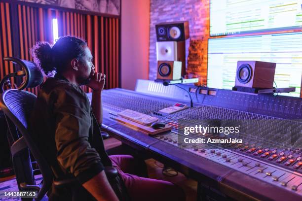 focused black male sound engineer looking at the computer screen in a recording studio - recording studio stock pictures, royalty-free photos & images