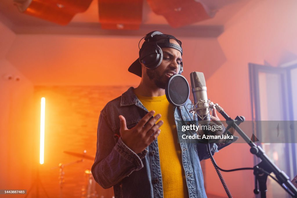 Young Adult Black Male Music Singer Passionately Singing In A Beautiful Illuminated Studio