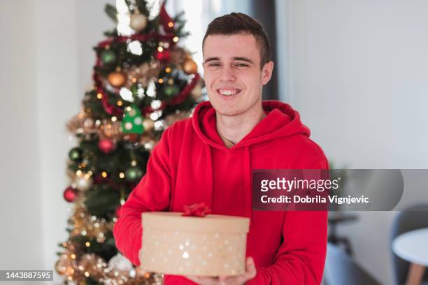 glückliche junge kiste mit einer weihnachts-mystery-box - teenager boy shopping stock-fotos und bilder