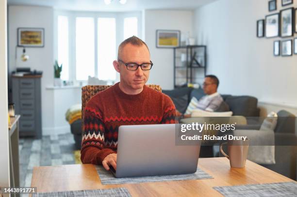 mature man using a laptop in his living room - blind man ストックフォトと画像