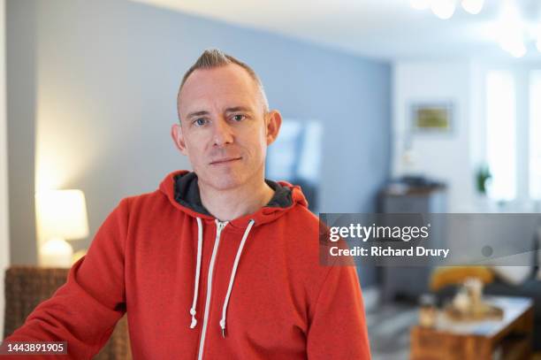 portrait of a mature man in his living room - lgbtqi stock pictures, royalty-free photos & images