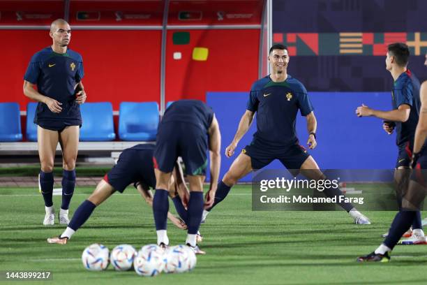 Cristiano Ronaldo of Portugal stretches next to Pepe during the Portugal Training Session at Grand Hamad Stadium on November 23, 2022 in Doha, Qatar.