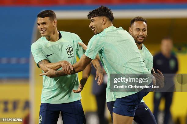 Thiago Silva, Neymar and Lucas Paqueta of Brazil warm up during Brazil match day -1 training session at Al Arabi SC Stadium on November 23, 2022 in...